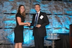 Woman and a man on stage, accepting an award